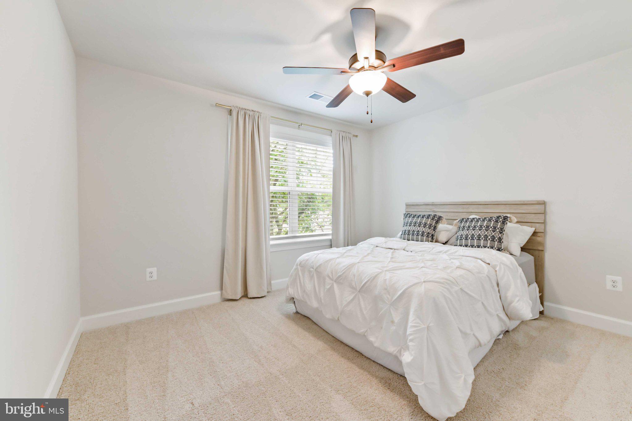 6310 Winters Lane Hanover, MD 21076 - Photo 41 of 76 a bedroom with a large bed chandelier and a window