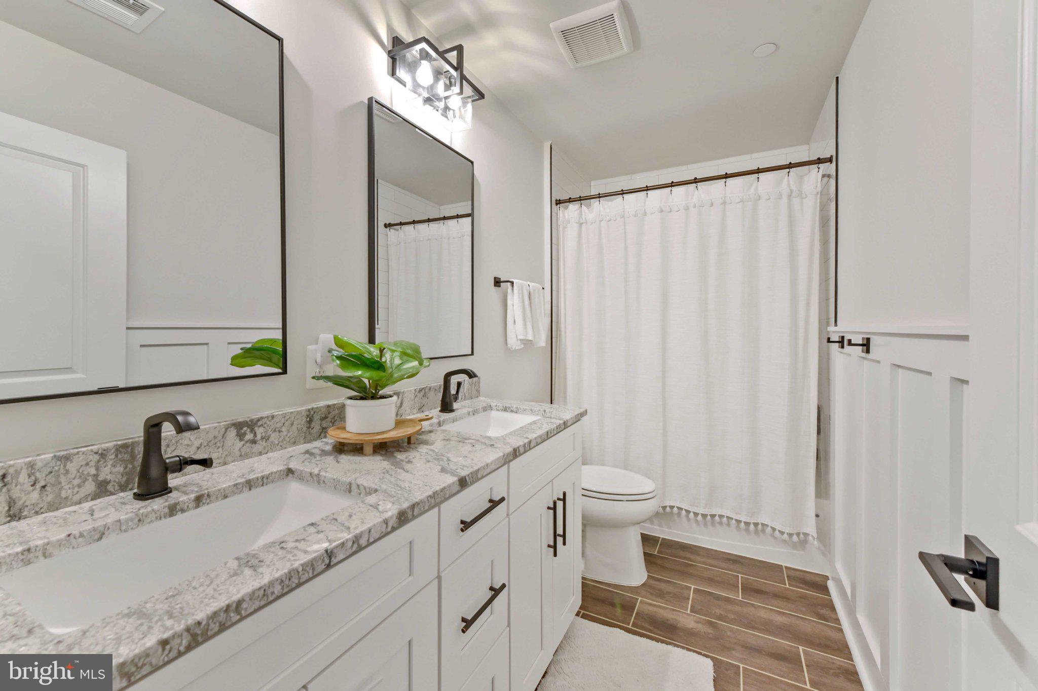 6310 Winters Lane Hanover, MD 21076 - Photo 50 of 76 a bathroom with a granite countertop sink a toilet and a mirror