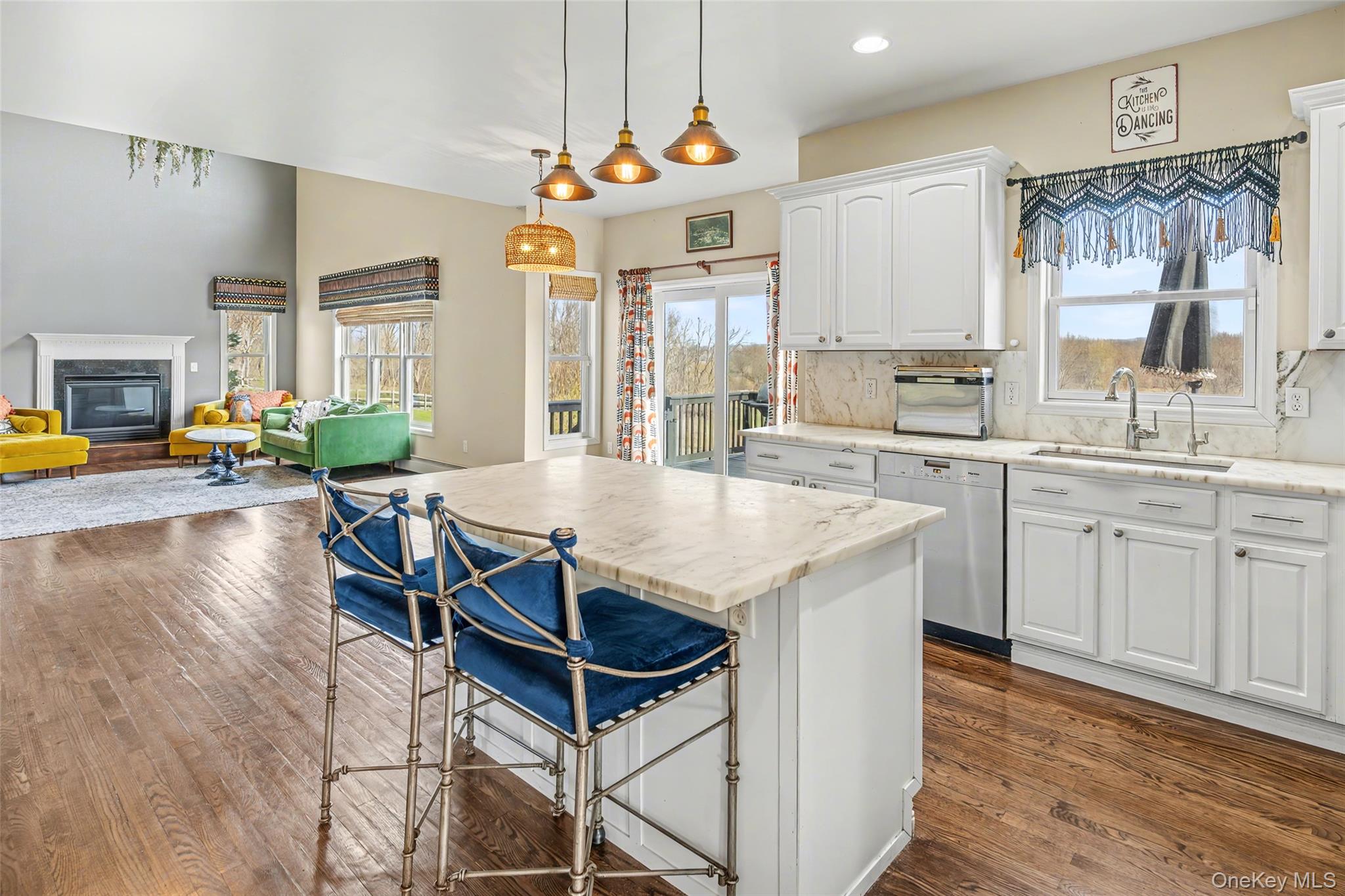 67 Liberty Corners Road Pine Island, NY 10969 - Photo 13 of 42 a kitchen with stainless steel appliances granite countertop a stove top oven a sink a dining table and chairs with wooden floor