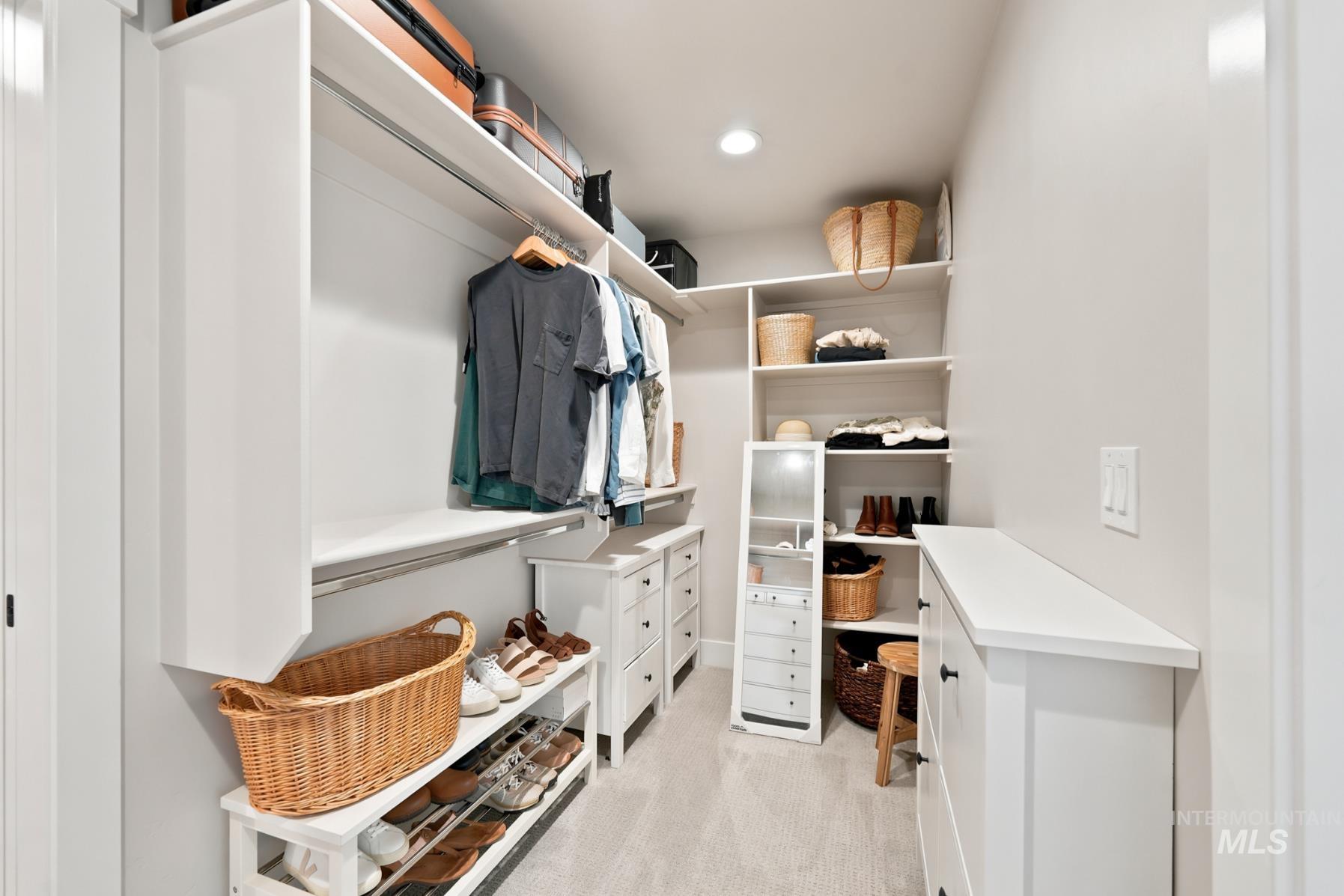 6933 South Zenith Avenue Meridian, ID 83642 - Photo 23 of 34 Custom closet system featuring white cabinetry, multiple hanging rods, integrated shelving, built-in drawers, and recessed lighting