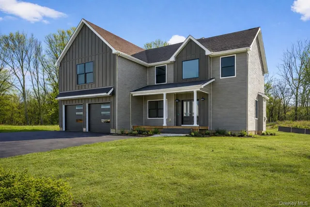 a front view of a house with yard and green space