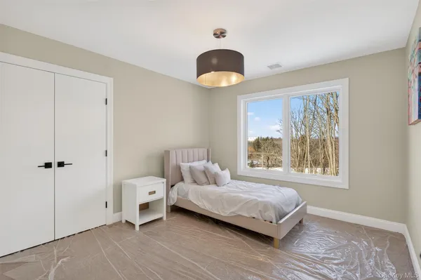a bedroom with a bed and a large window