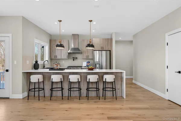 a kitchen with stainless steel appliances granite countertop a dining table chairs stove refrigerator and cabinets
