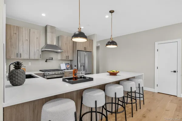 a kitchen with stainless steel appliances a table chairs and white cabinets
