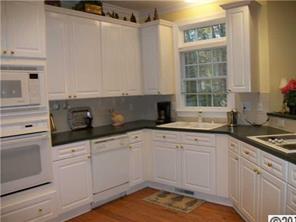 3336 Rhett Butler Place Charlotte, NC 28270 - Photo 10 of 16 a kitchen with granite countertop a sink stainless steel appliances white cabinets and a window