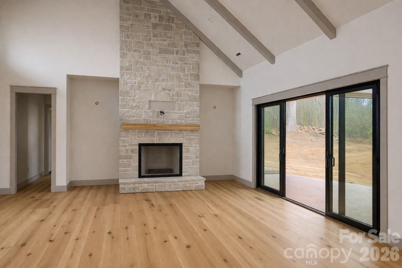 25 Emory Paige Road Weaverville, NC 28787 - Photo 6 of 20 a view of an empty room with wooden floor fireplace and a window