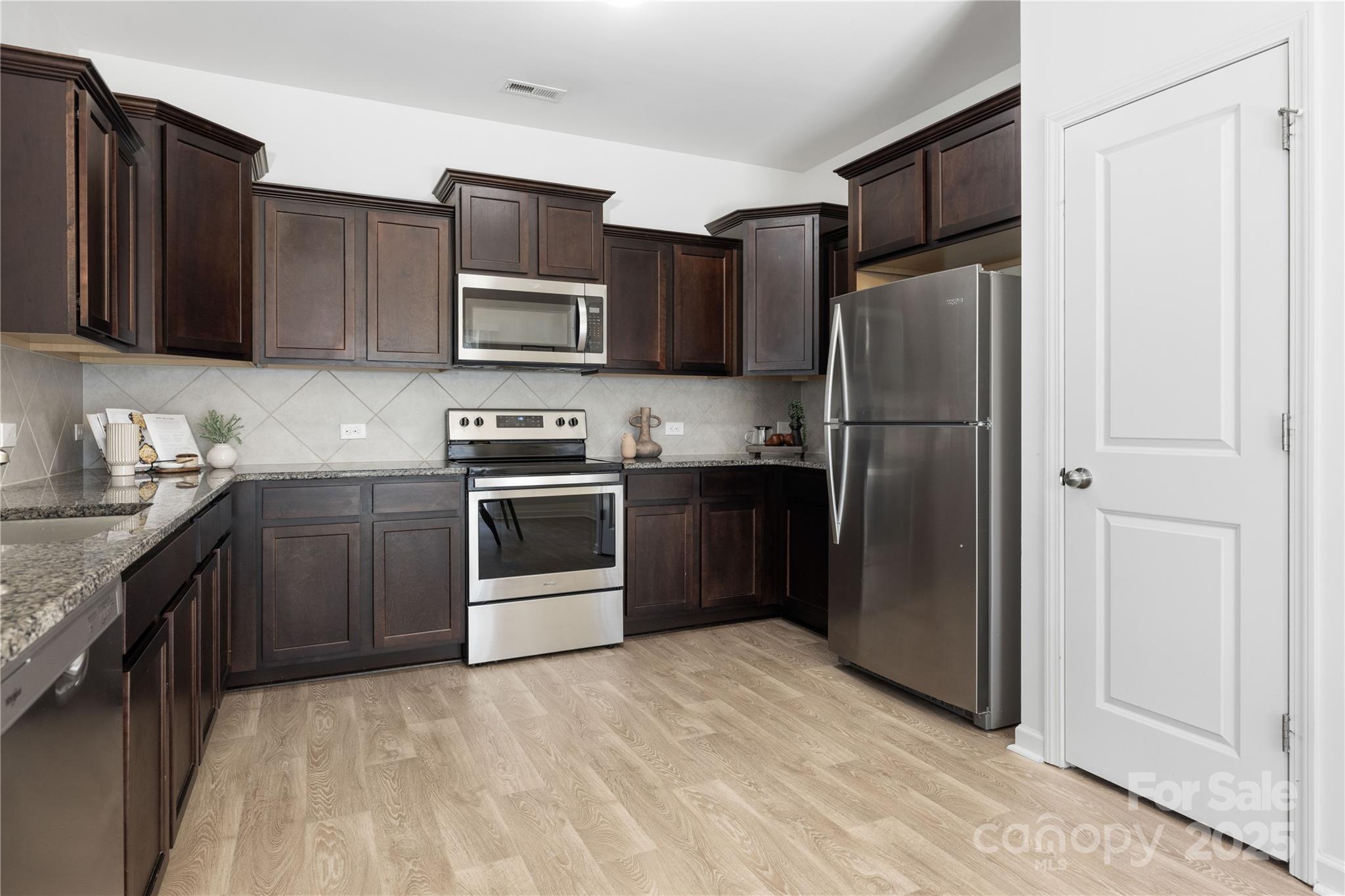12536 Gotland Road, Unit 330 Midland, NC 28107 - Photo 11 of 28 a kitchen with stainless steel appliances granite countertop a refrigerator stove and sink