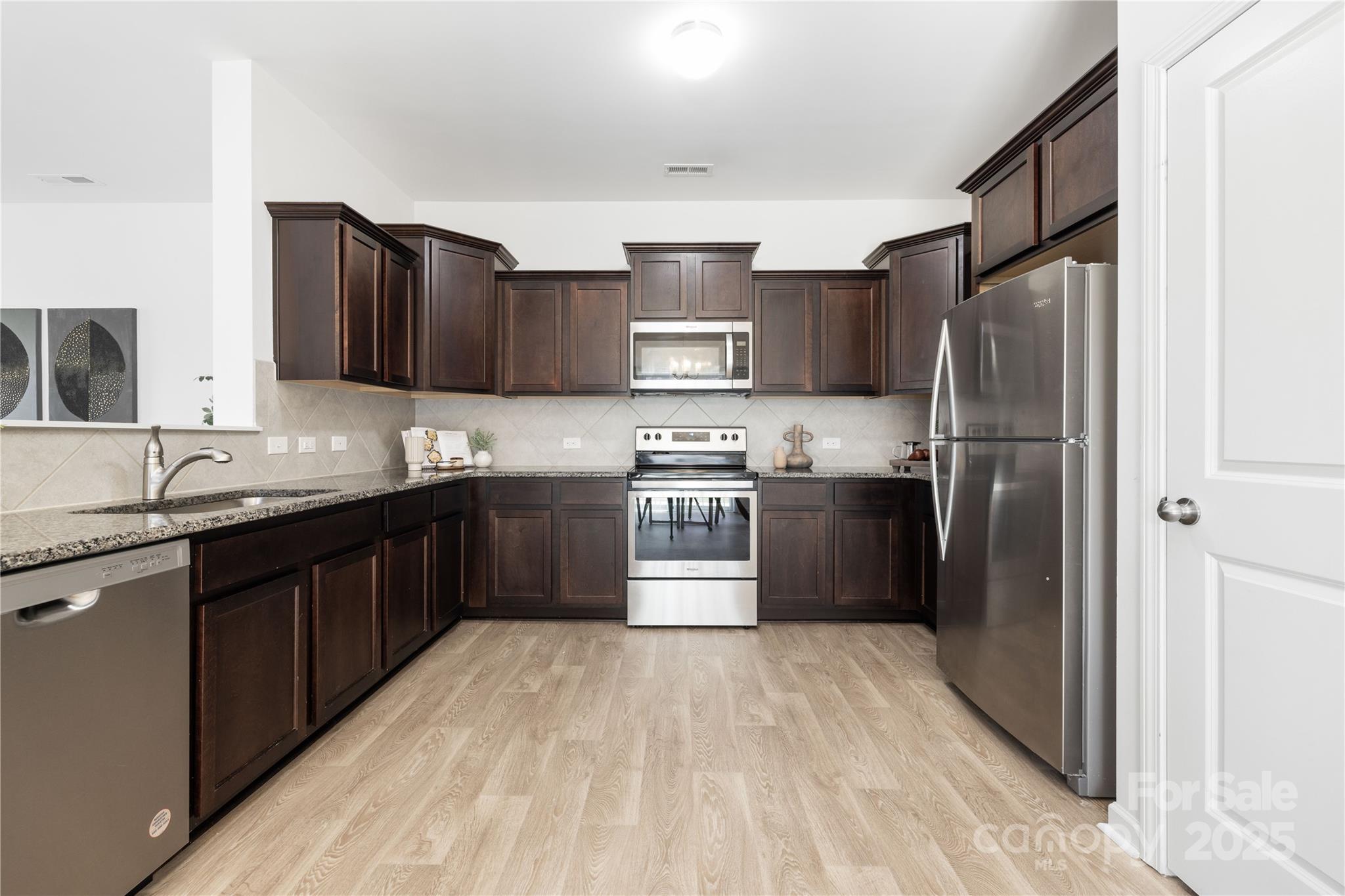 12536 Gotland Road, Unit 330 Midland, NC 28107 - Photo 12 of 28 a kitchen with stainless steel appliances granite countertop a refrigerator stove and sink