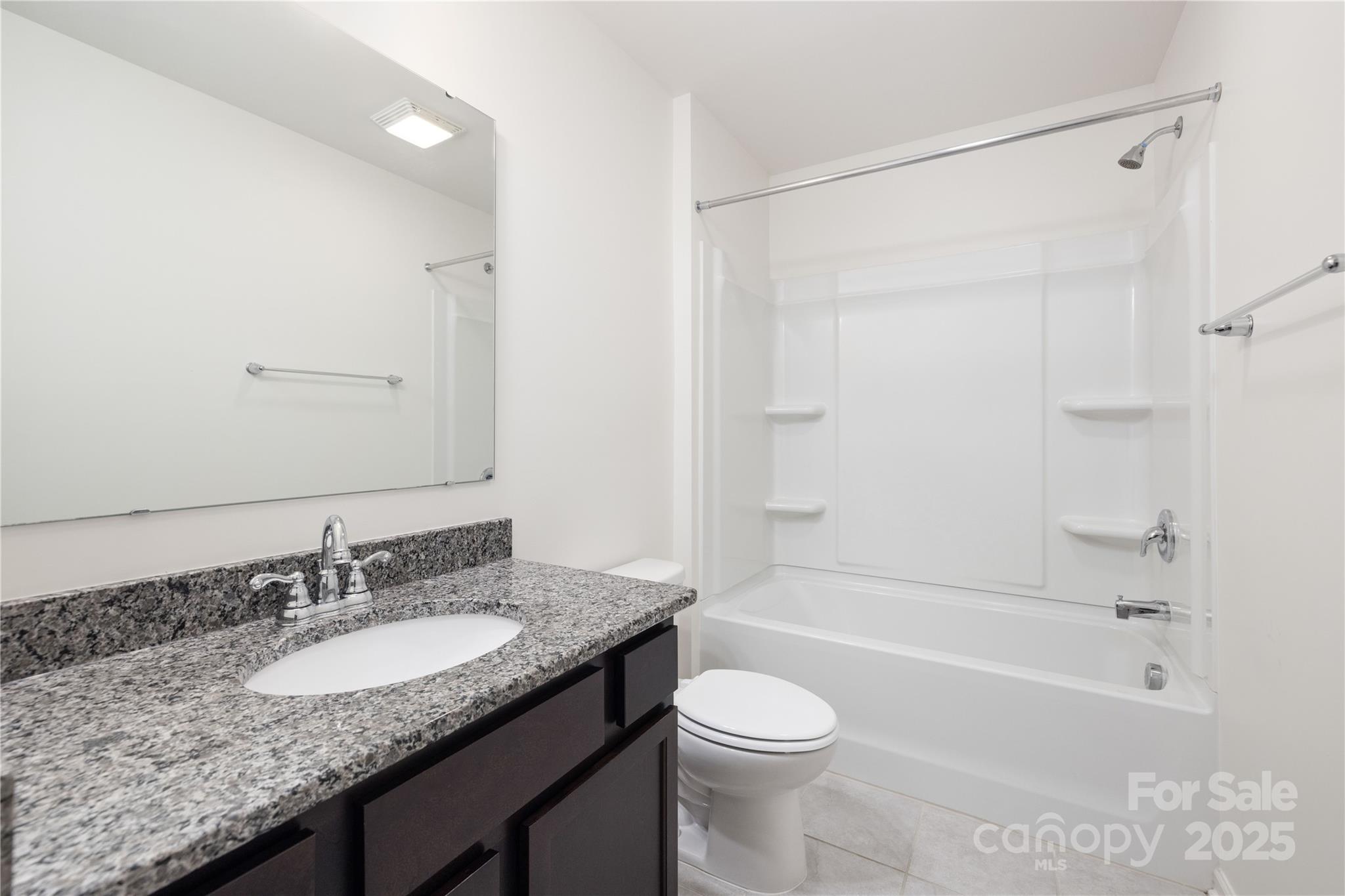 12536 Gotland Road, Unit 330 Midland, NC 28107 - Photo 26 of 28 a bathroom with a granite countertop sink a toilet and shower