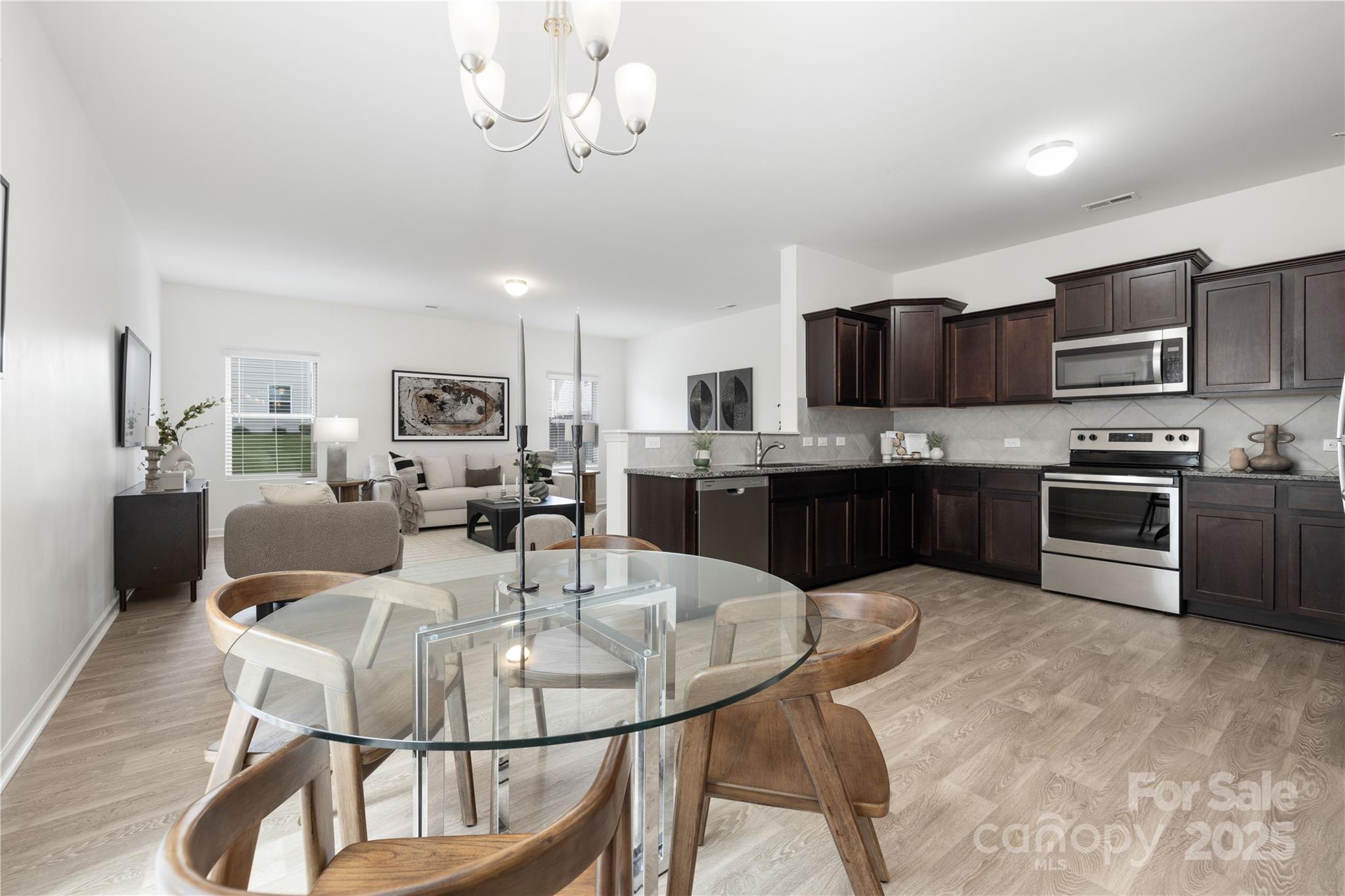 12536 Gotland Road, Unit 330 Midland, NC 28107 - Photo 8 of 28 a kitchen with stainless steel appliances kitchen island granite countertop a dining table and chairs