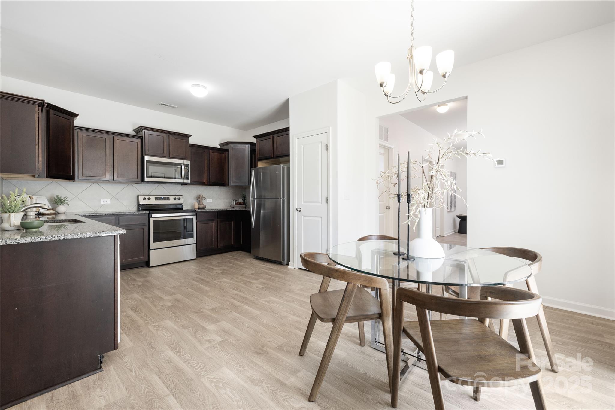 12536 Gotland Road, Unit 330 Midland, NC 28107 - Photo 9 of 28 a kitchen with stainless steel appliances a table and chairs in it