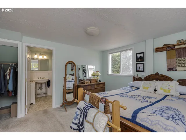 a bedroom with a bed and a dresser with mirror