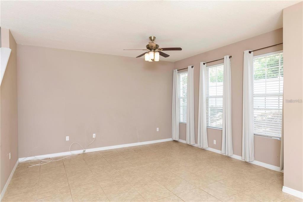 8409 Blue Rock Drive New Port Richey, FL 34653 - Photo 14 of 36 an empty room with chandelier fan and windows