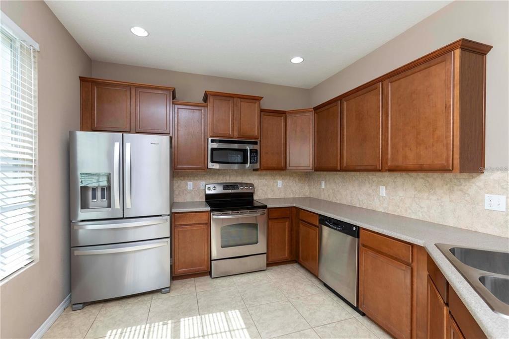8409 Blue Rock Drive New Port Richey, FL 34653 - Photo 3 of 36 a kitchen with stainless steel appliances granite countertop a refrigerator stove and sink