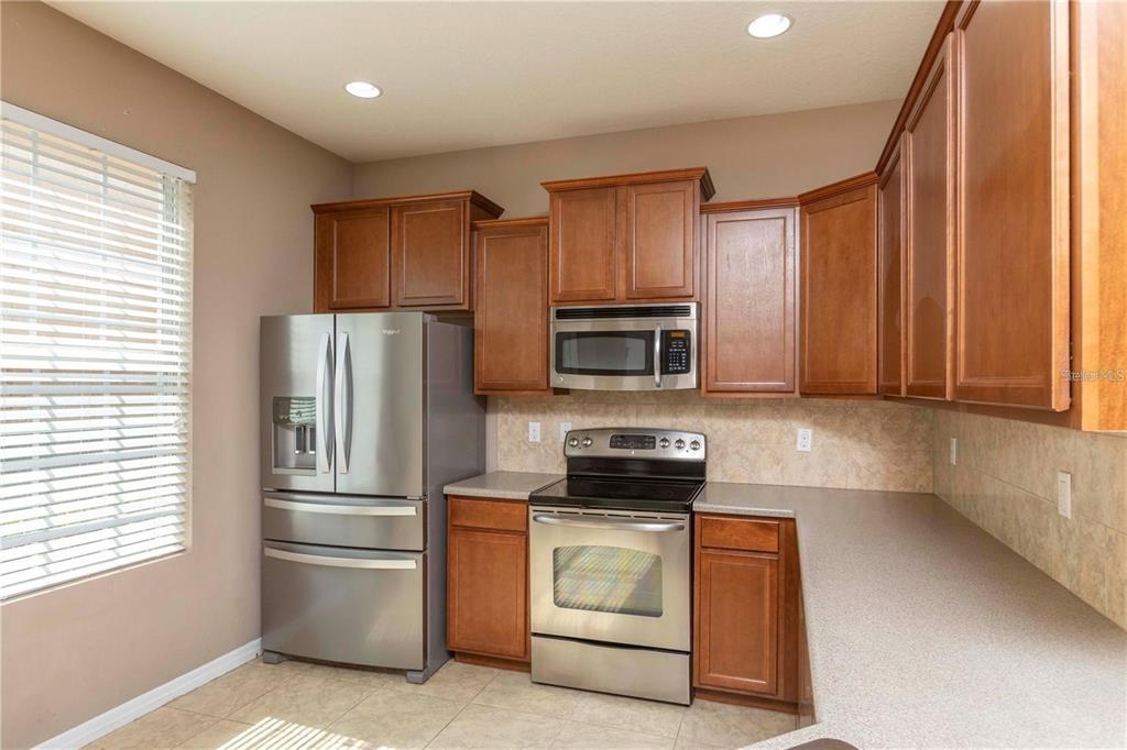 8409 Blue Rock Drive New Port Richey, FL 34653 - Photo 4 of 36 a kitchen with appliances a microwave and cabinets