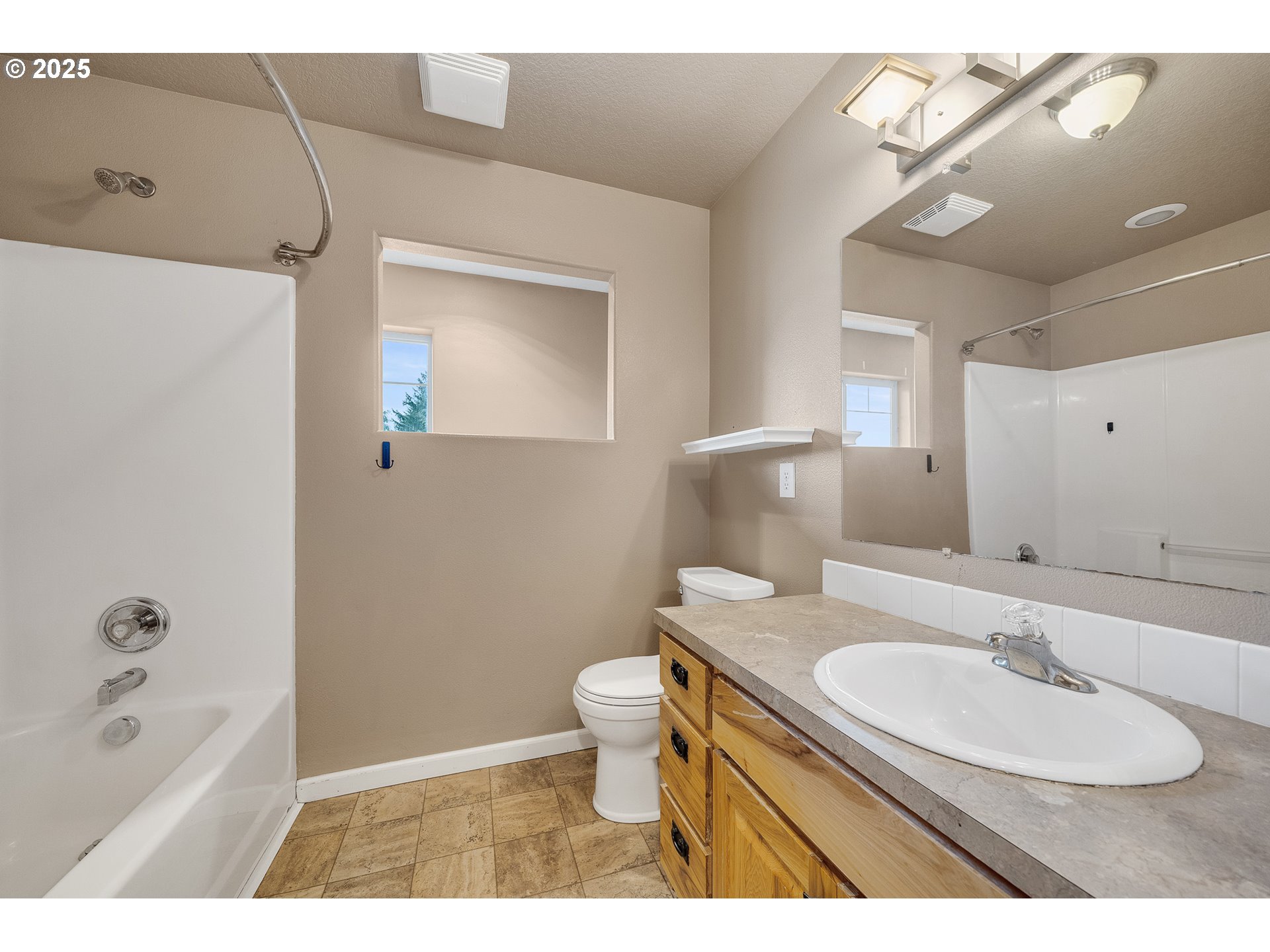 3355 Hubert Road Tillamook, OR 97141 - Photo 19 of 35 a bathroom with a granite countertop sink a toilet and bathtub