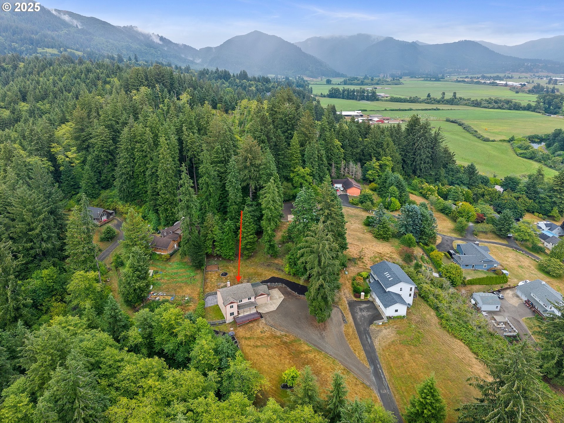 3355 Hubert Road Tillamook, OR 97141 - Photo 6 of 35 an aerial view of green landscape with trees houses and mountain view