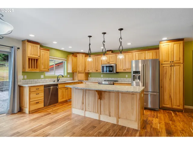 a kitchen with stainless steel appliances granite countertop sink stove and refrigerator