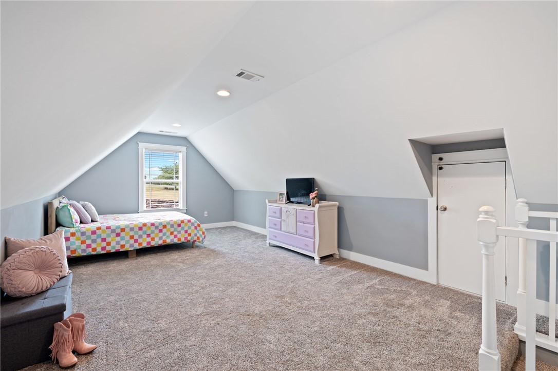1050 Old Dacusville Road Easley, SC 29640 - Photo 22 of 33 This airy bedroom features sloped ceilings and ample space, creating a versatile and comfortable living area.