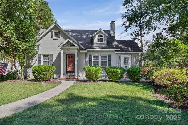 a front view of a house with a yard and potted plants