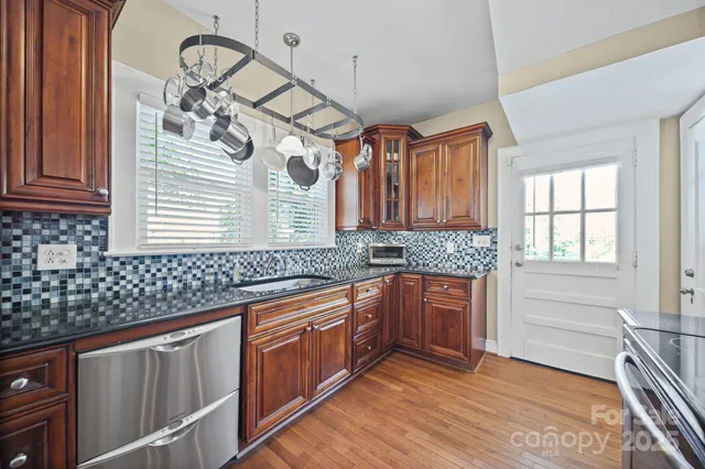 a kitchen with stainless steel appliances granite countertop a sink and cabinets