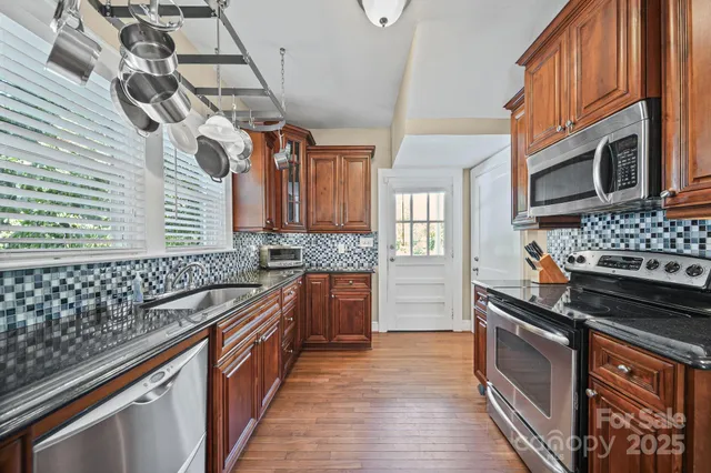 a kitchen with stainless steel appliances granite countertop a stove and a sink