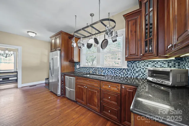 a kitchen with stainless steel appliances granite countertop a stove a sink and a refrigerator