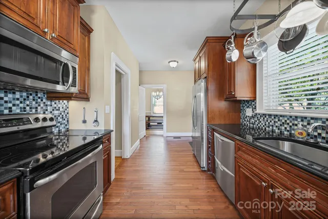 a kitchen with stainless steel appliances granite countertop a stove and a microwave