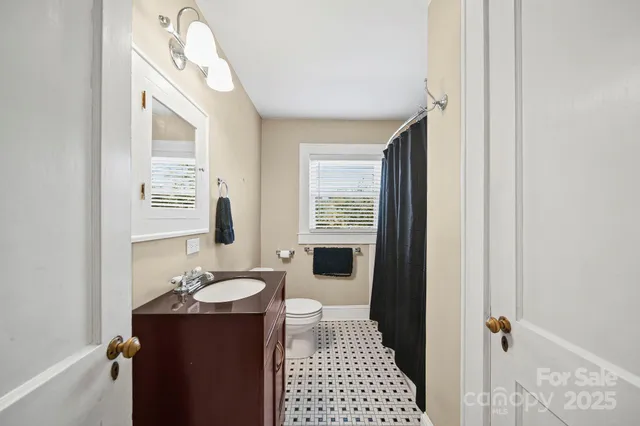 a bathroom with a sink and mirror with bathtub
