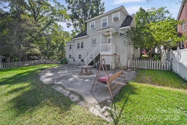 a view of a house with backyard and sitting area