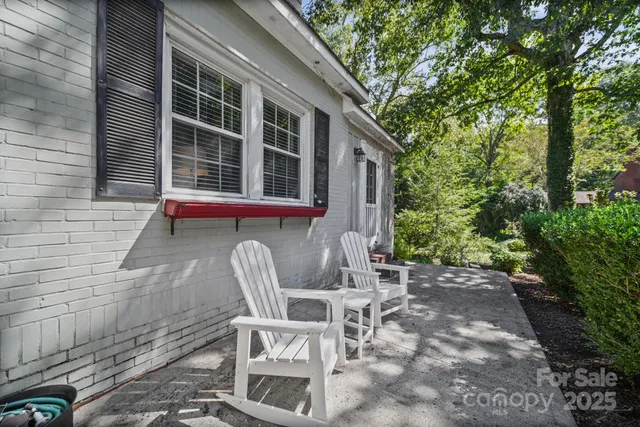 a view of a chair and table in backyard of the house