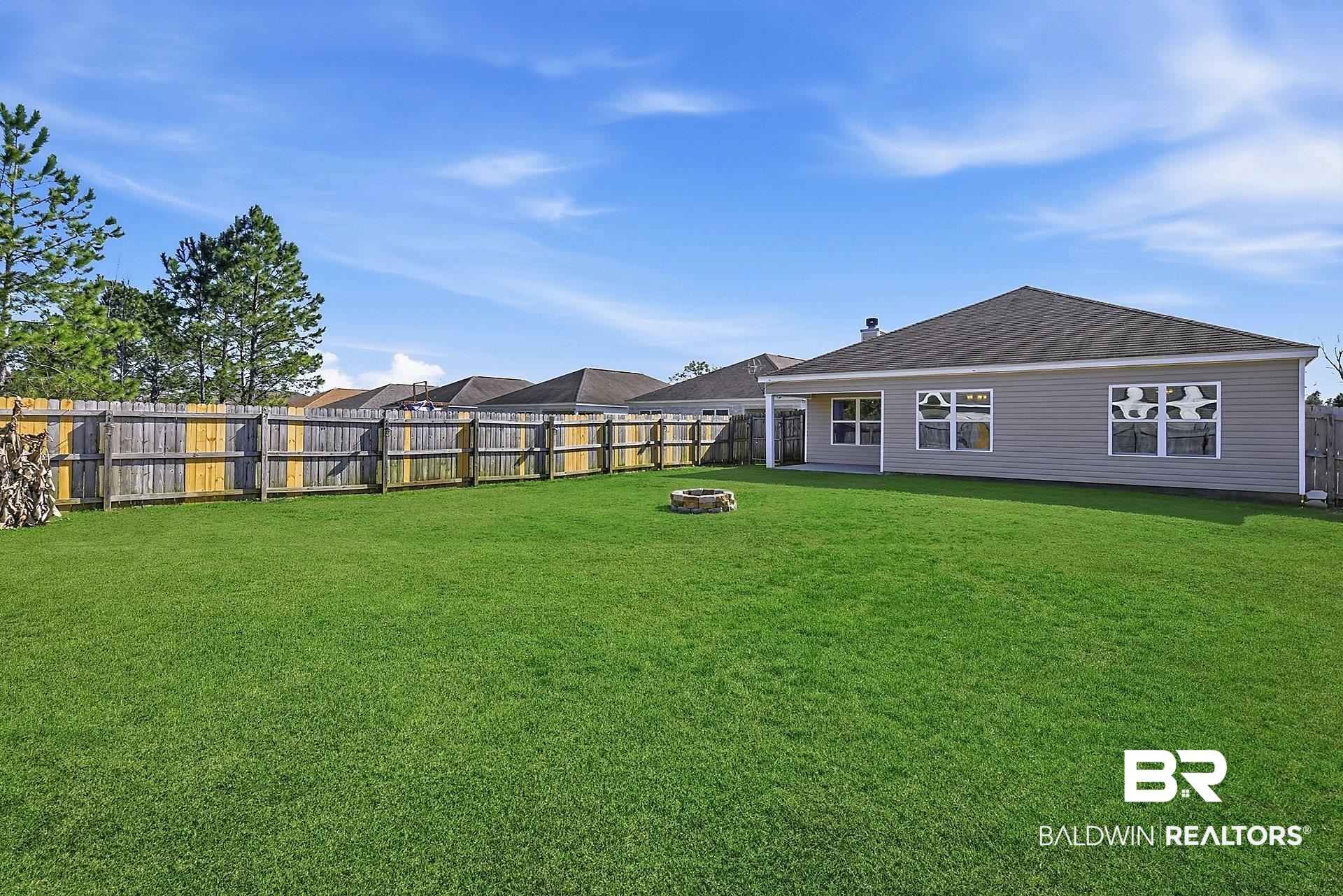 983 Summerton Drive Foley, AL 36535 - Photo 4 of 25 Rear view of property featuring an outdoor fire pit, a fenced backyard, a patio, and roof with shingles