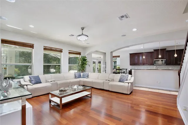 a living room with furniture kitchen view and a large window