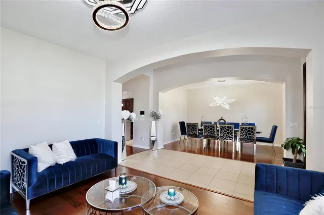 a living room with furniture a rug and a large mirror