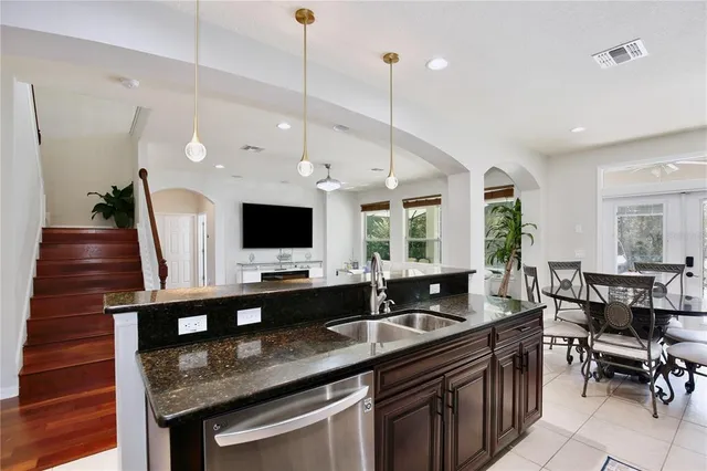 a kitchen with stainless steel appliances granite countertop a sink and a table