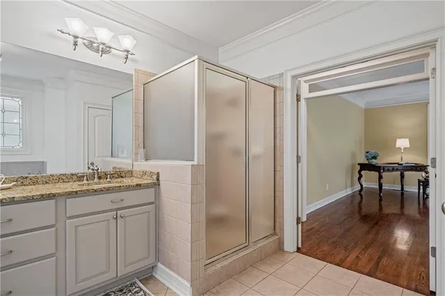 a bathroom with a granite countertop sink a mirror and a shower