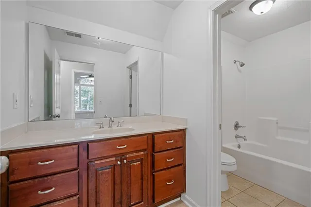 a bathroom with a granite countertop double vanity sink a mirror and a bathtub