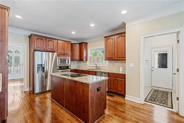 a kitchen with stainless steel appliances granite countertop a stove top oven a refrigerator a sink and dishwasher