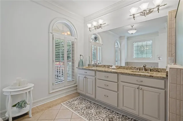a spacious bathroom with a granite countertop sink a toilet a mirror and a shower