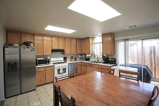 a kitchen with stainless steel appliances granite countertop a stove a sink dishwasher a refrigerator and a microwave oven with wooden floor