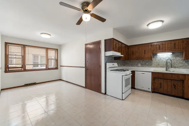 a kitchen with stainless steel appliances granite countertop a refrigerator a sink dishwasher a stove with wooden cabinets and floor