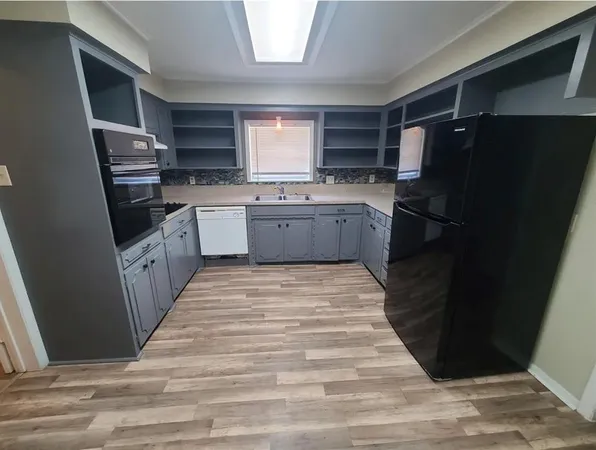 a large kitchen with a stove a refrigerator and a sink