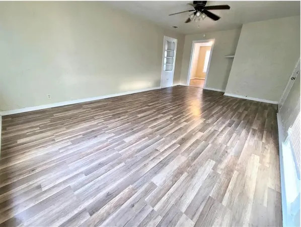a view of a livingroom with wooden floor and a ceiling fan
