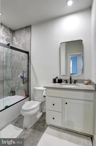a bathroom with a sink a toilet a mirror and shower