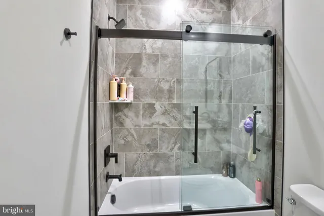 a bath tub sitting next to a white sink and a shower