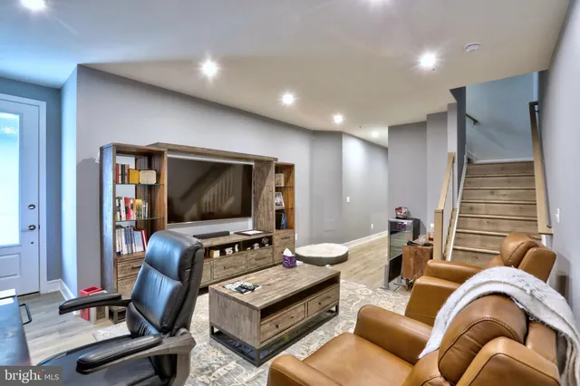 a living room with furniture flat screen tv and gym equipment