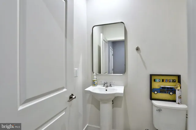 a bathroom with a sink toilet and mirror