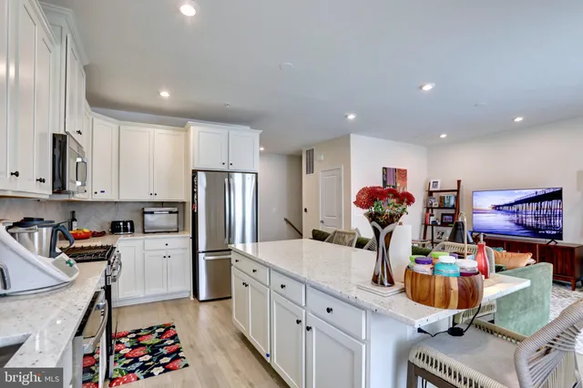 a kitchen with stainless steel appliances granite countertop a sink refrigerator and cabinets