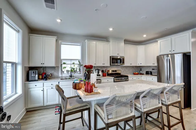 a kitchen with a dining table chairs refrigerator and cabinets