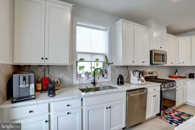 a kitchen with stainless steel appliances granite countertop a sink a stove and cabinets